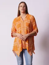 Camisa celeste con estampado de cachemir en blanco, cuello a la base, escote en V y abertura central con botones. Terminación de ruedo asimétrico. Manga 3/4 de largo regulable con presilla y botón.