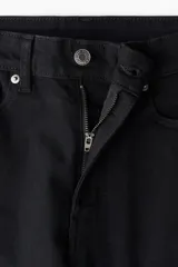 Jean skinny de tiro alto y color negro, con diseño clásico de cinco bolsillos, cierre de cremallera y botón metálico.