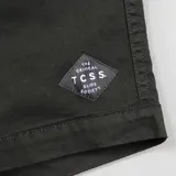 Bermuda de algodón color negro, con cintura elástica y cordón de ajuste color crema. Presenta bolsillos laterales y un pequeño parche con texto en la parte inferior derecha.