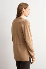 Ruana negra de tejido de punto, con mangas largas y cordón ajustable en la cintura.
