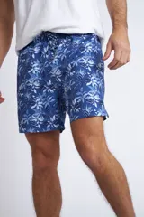 Short de baño con cintura elástica y cordón ajustable, confeccionado en tela ligera de secado rápido. Presenta un estampado botánico integral en tonos amarillos, blancos y azules, con dos bolsillos delanteros y uno posterior.