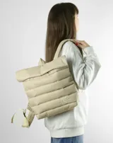 Mochila acolchada color beige con cierre superior enrollable y hebilla.