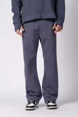 Pantalón de jogging de corte recto y fit relajado, confeccionado en tejido de algodón de color gris azulado. Presenta una caída amplia, cintura elástica y un pequeño logo bordado en la parte superior del muslo.