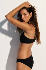 Top de bikini negro con breteles finos y textura acanalada.