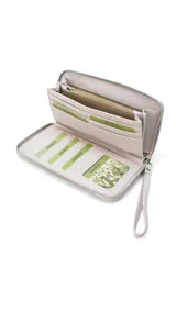 Billetera larga con cierre perimetral, confeccionada en material sintético texturizado color mostaza. Cuenta con correa de mano extraíble y placa metálica con logo de la marca en el frente.