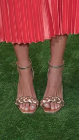 Sandalias de tacón color champagne con tira fina al tobillo y tira ancha trenzada en el empeine.