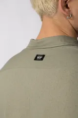 Camisa de manga larga con cuello clásico y cierre frontal de botones. Presenta un calce relajado y una textura liviana.