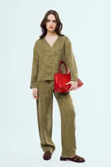 Pantalón largo color verde militar de corte recto, tiro alto y diseño holgado.