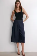 Body negro de escote cuadrado y tirantes anchos, con cierre de broches en la parte inferior.