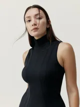 Vestido negro midi ajustado al cuerpo, sin mangas y con cuello alto.