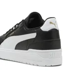 Championes urbanos Puma modelo Shuffle Downtown, color negro con franja lateral blanca y suela de plataforma blanca. Presenta detalles en dorado en el logo lateral y lengüeta.