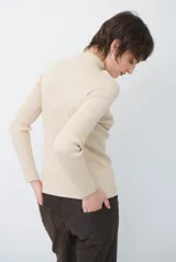 Polera de tejido morley color azul, con cuello alto y mangas largas, de corte ajustado al cuerpo.