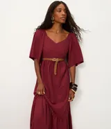 Vestido midi color bordó, con escote en V, mangas cortas evasé y falda en capas con recorte tipo María. La parte trasera tiene elástico para un mejor ajuste. Confeccionado en viscosa certificada y poliamida.