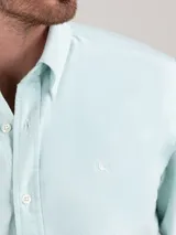 Camisa oxford de hombre color verde menta, con corte regular fit, cuello buttondown y manga larga con puño simple. Presenta cierre frontal de botones y pequeño logo bordado en el pecho.