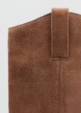 Bota de caña alta estilo cowboy confeccionada en piel de serraje color marrón, con tacón rectangular y punta fina.