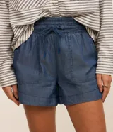 Short runner de jeans color azul, con cintura elástica ajustable con lazo, bolsillos grandes aplicados en el frente y bajo redondeado.
