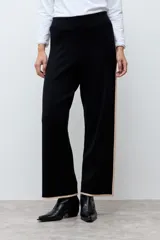 Pantalón tejido de corte recto y tiro alto, color negro con detalles de líneas laterales en tono beige. Posee cintura elástica para mayor comodidad.