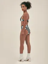 Bikini con estampado abstracto en blanco y negro, compuesto por un corpiño triangular con tirantes finos y una bombacha de talle alto con faja ancha.