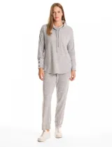 Buzo de tejido suave con cuello volcado ajustable mediante cordones con punteras metálicas. Presenta mangas largas con puños decorados con botones metálicos, hombros caídos y ruedo redondeado con aberturas laterales.