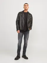 Jean de corte slim fit con tiro bajo, confeccionado en denim elástico de color gris oscuro con efecto lavado. Presenta diseño clásico de cinco bolsillos, cierre frontal con botón y costuras reforzadas.