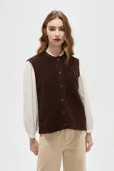 Chaleco de punto texturizado en color marrón chocolate, con cuello redondo y cierre frontal de botones a tono.