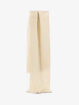 Chal de estilo clásico color beige, confeccionado en tejido suave con sutiles hilos metalizados y terminación de flecos cortos en los extremos.