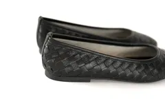 Bailarinas de cuero gamuzado negro con efecto tramado entrelazado.