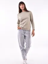 Remera de manga larga color beige, con cuello redondo y estampado frontal que dice "Magic is something you make" en color lila.