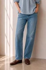 Jean de corte recto y tiro medio color celeste, con bolsillos laterales y traseros, confeccionado en denim de algodón elástico.