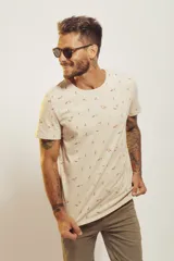 Remera de cuello redondo y manga corta, color beige con estampado de pequeños motivos playeros.