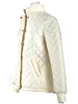 Campera negra capitoneada con paneles laterales acanalados, cuello alto y cierre con botones a presión.