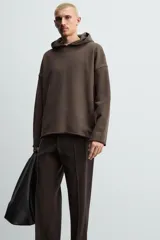 Sudadera tipo hoodie de corte relajado, confeccionada en tejido de algodón con interior de rizo. Presenta cuello con capucha, manga larga y acabados con bordes enrollados.