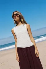 Top de punto color blanco, con cuello redondo y diseño sin mangas.
