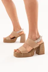 Sandalias de cuero color beige con plataforma, taco ancho y doble tira frontal. Cuentan con tira en el talón con hebilla metálica de ajuste.