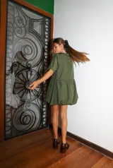 Vestido corto color verde oliva, de manga corta y corte holgado con frunce en la cintura que genera un efecto de falda globo (balloon).