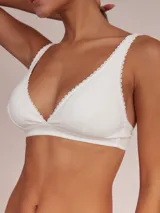 Soutien tipo halter de algodón color blanco, con diseño triangular y detalle de puntilla en los bordes.