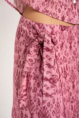 Short pollera color rosa con estampado abstracto en tonos borgoña y lazo lateral.