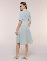 Vestido camisero midi de rayas blanco y verde, con cuello solapa, escote en V, mangas cortas y falda acampanada con vuelo.