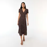 Vestido midi de color marrón con estampado de lunares claros, escote en V, mangas cortas y botones frontales.