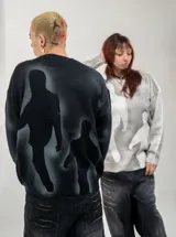 Buzo de punto negro con diseño estampado de siluetas humanas en gris difuminado, de cuello redondo y corte regular.