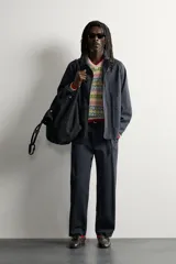 Pantalón chino regular fit confeccionado en algodón, color negro, con bolsillos frontales, bolsillos traseros de vivo con botón y cierre frontal con cremallera y botón. Colección especial Aaron Levine x ZARA.
