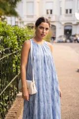 Vestido midi de corte amplio y silueta recta, con cuello redondo y diseño sin mangas. Presenta un estampado tipo tie-dye en tonos azules y blancos, confeccionado en una mezcla de algodón y poliéster.
