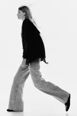 Jeans de cinco bolsillos en denim de algodón rígido, color gris claro lavado. Presenta un corte de cintura ultra alta, pierna amplia y recta desde la cadera hasta el bajo, con un estilo levemente largo.