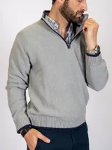 Sweater gris claro de tejido de punto con medio cierre frontal y cuello alto.