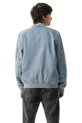 Campera tipo bomber confeccionada en denim lavado, con cierre frontal, cuello, puños y ruedo en tejido rib elástico. Presenta bolsillos laterales y un bolsillo utilitario con cierre en la manga izquierda.