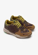 Zapatillas de trekking Satorisan modelo Chacrona Pull Up, confeccionadas en cuero marrón, nobuk y serraje. Presentan suela con tacos y gran agarre, detalles en color verde y beige, y sistema de cordones dobles.