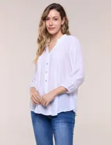 Blusa de silueta suelta color azul, con escote en V y cuello mao. Cuenta con abotonadura frontal, alforzas verticales en el pecho y mangas tres cuartos con puños elastizados.