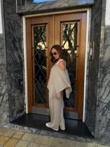 Pantalón de lanilla color beige, de corte recto y tiro alto, con diseño holgado y fluido.