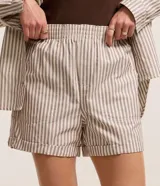 Short de tiro alto confeccionado en sarga de algodón a rayas, con cintura elástica, bolsillos laterales y ruedo plegado.