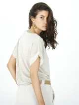 Remera color beige de lino con ribetes de lurex, corte holgado y mangas cortas.
